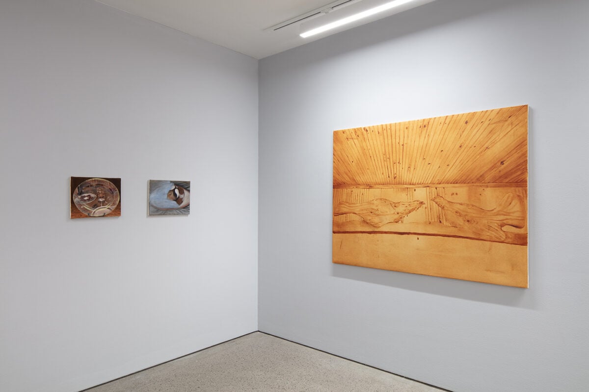 Installation view of ‘Iiris Riihimäki: Tea Bladder’ with oil paintings on a grey wall.
