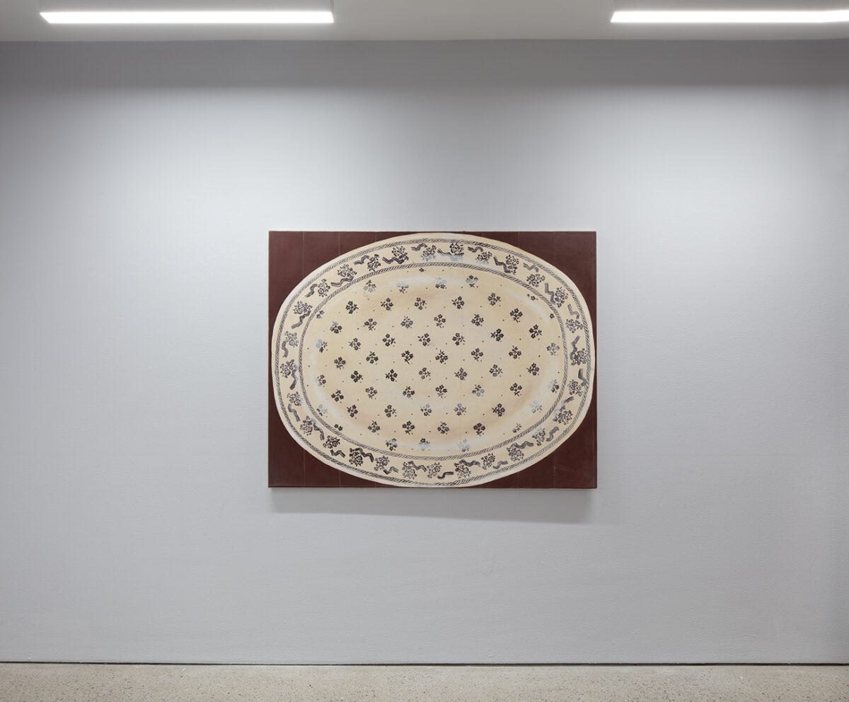 Installation view of ‘Iiris Riihimäki: Tea Bladder’ with the painting Mother’s Lore (2024) showing a stencilled Laura Ashley plate on a painted table.