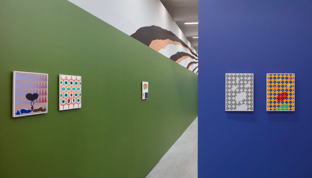 Installation view of the exhibition ‘Kasper Bosmans: A Cameo Appearance‘ with a dark green and a blue wall with small light coloured paintings.
